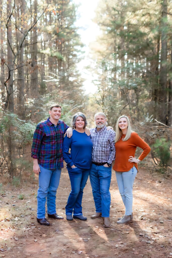 Smiling family gathered under colorful fall foliage in Jetton Park.